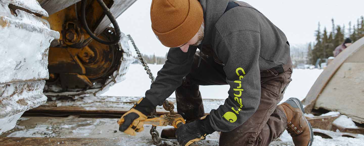 Carhartt Man fixing equipment wearing a sweatshirt